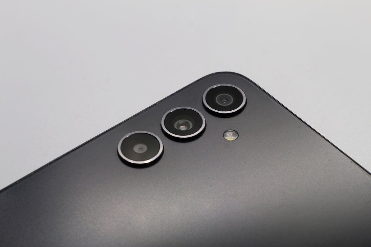 Close-up of a sleek smartphone with triple camera lenses and matte finish.